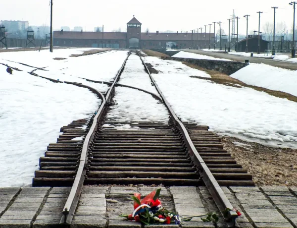 Wartownia i brama główna Auschwitz II (Birkenau), widok z rampy wewnątrz obozu, kwiaty